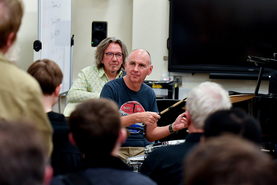 Neal Wilkinson playing percussion, looking towards an audience