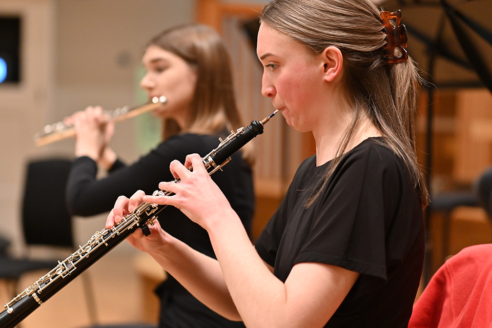Woodwind students playing oboe and flute in rehearsal Woodwind students playing oboe and flute in rehearsal
