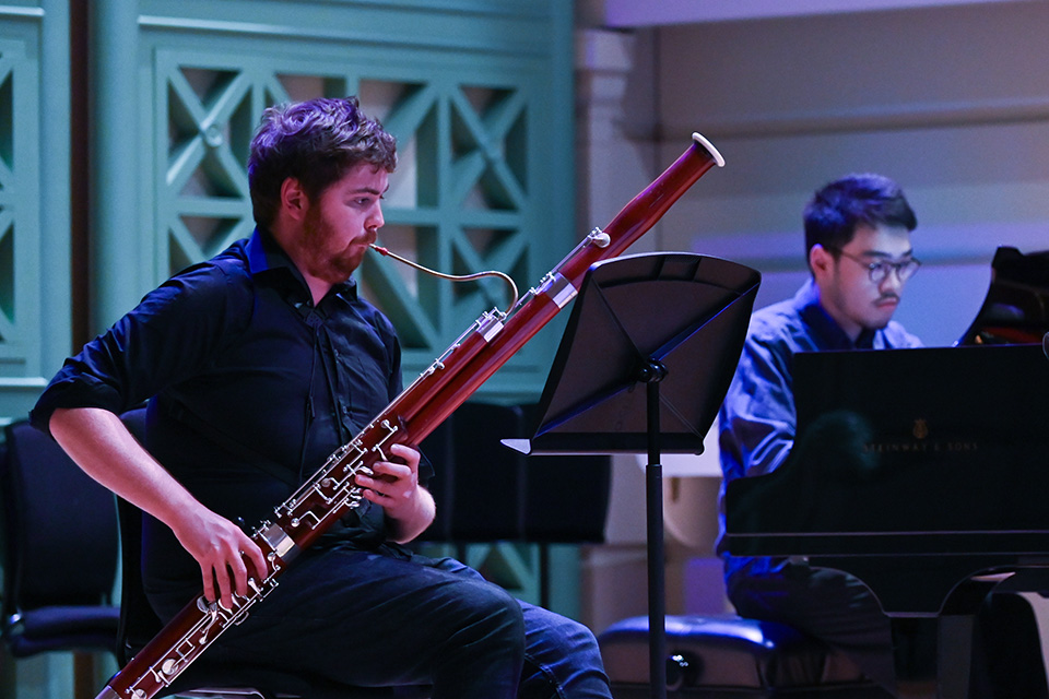 A bassonist performs with a chamber group on stage 