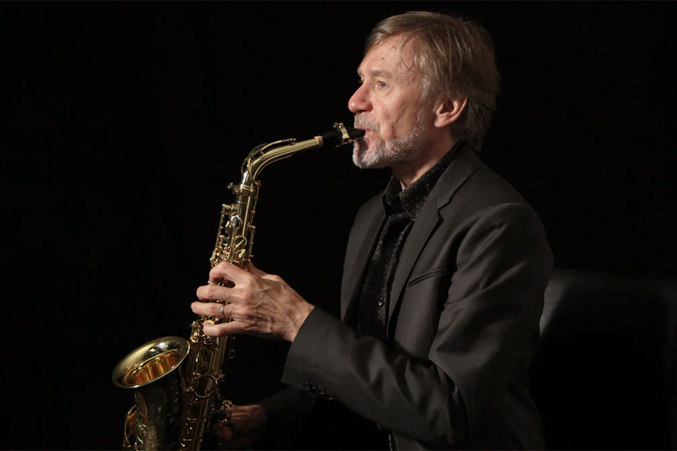 Claude Delangle plays his saxophone in a dark room