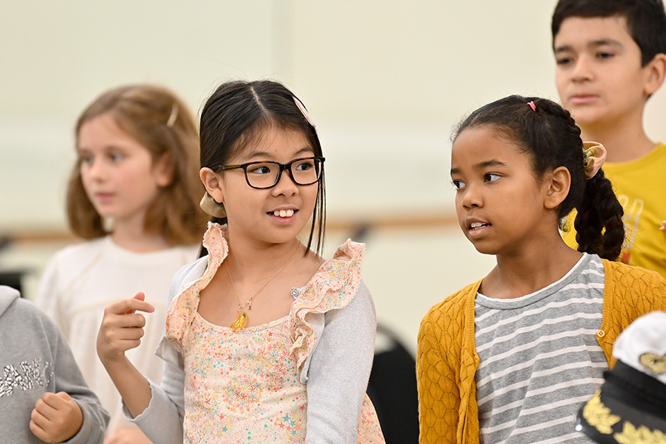 Two young girls smile as they take part in a group activity