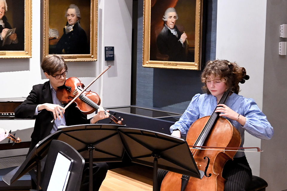 A violist and cellist perform in the RCM Museum