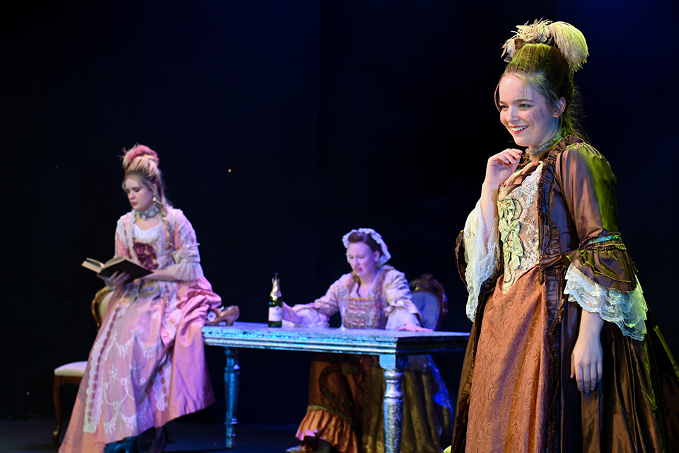 A trio of singers perform on the Britten Theatre stage dressed in historic costumes