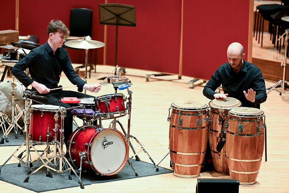 Two percussionists perform on stage