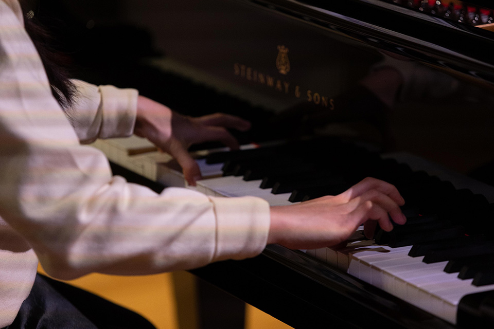 A close up shot of two hands playing a piano