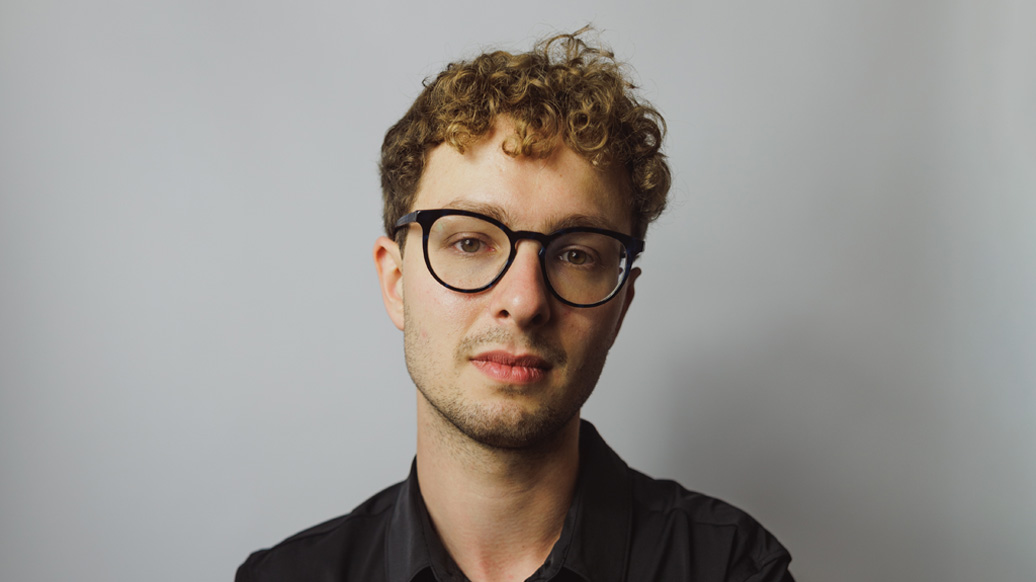 A man with short blonde hair, wearing glasses, smiling at the camera, wearing a black shirt. A man with short blonde hair, wearing glasses, smiling at the camera, wearing a black shirt.