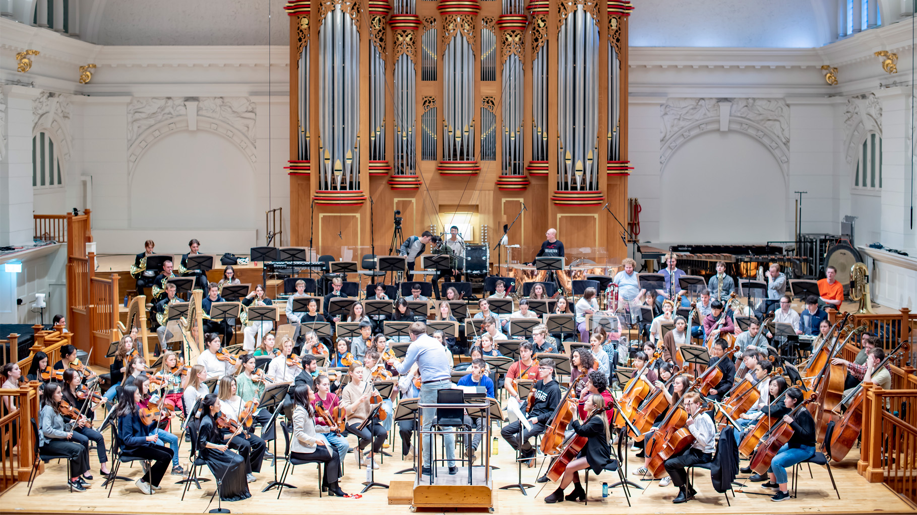 Vasily Petrenko conducting an orchestra with an organ in the background.