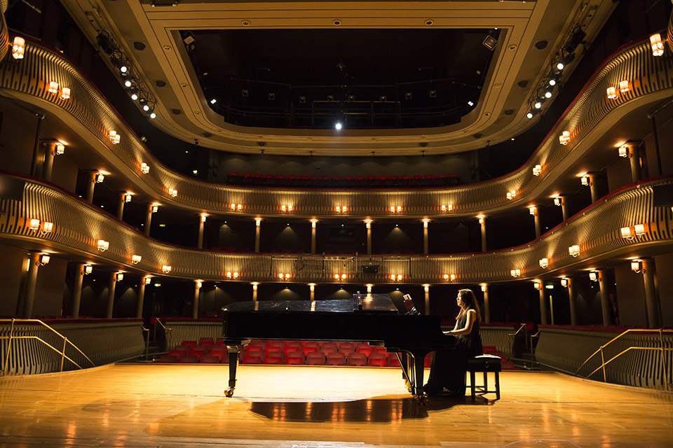 RCM student playing the piano on stage in the Britten theatre