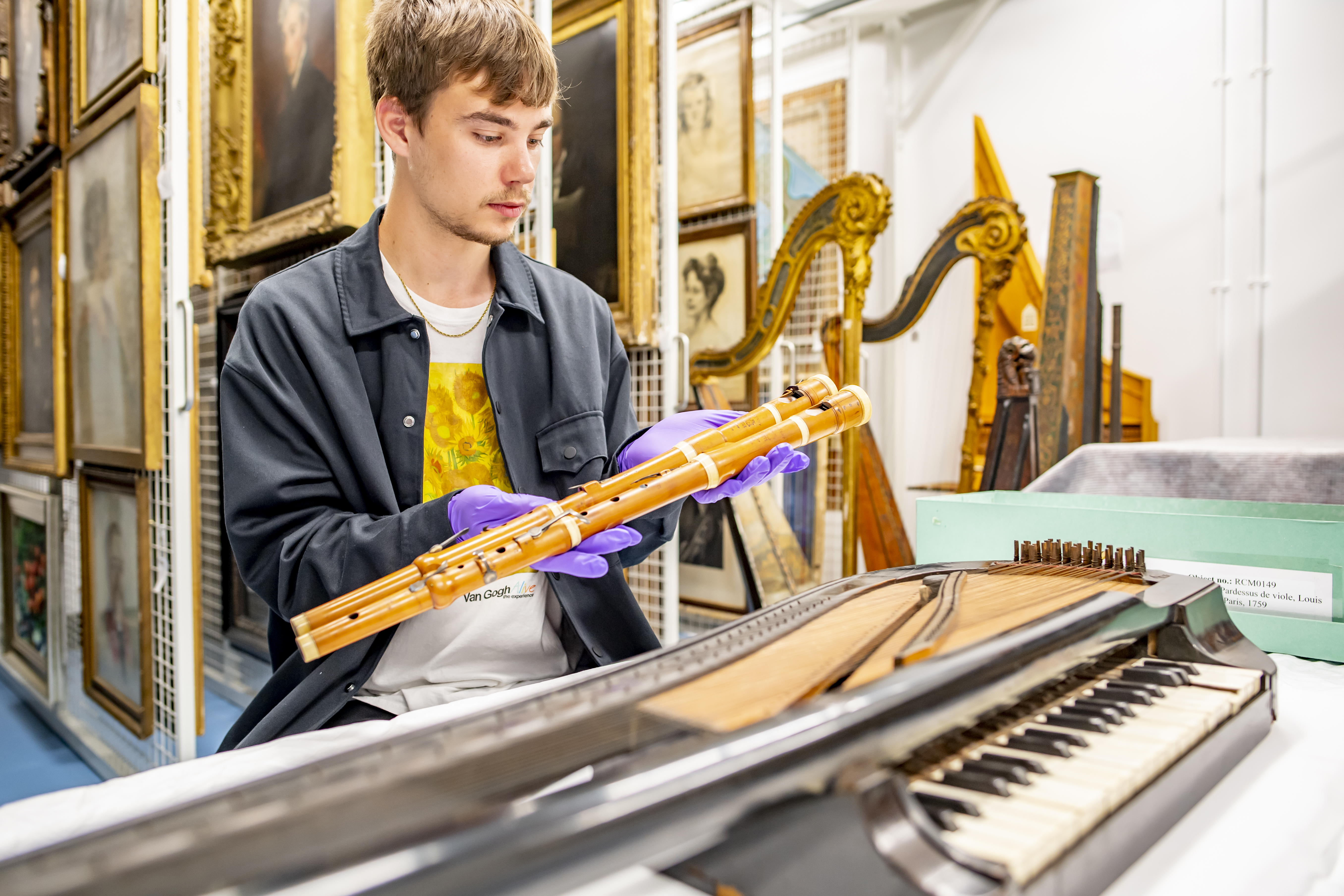 Man inspecting historical flute in Wolfson Centre.