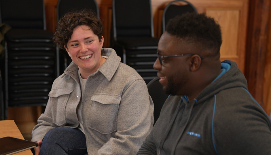 A black man chatting to a white women, who has a notepad, in the wooden-panelled Parry rooms. A black man chatting to a white women, who has a notepad, in the wooden-panelled Parry rooms.