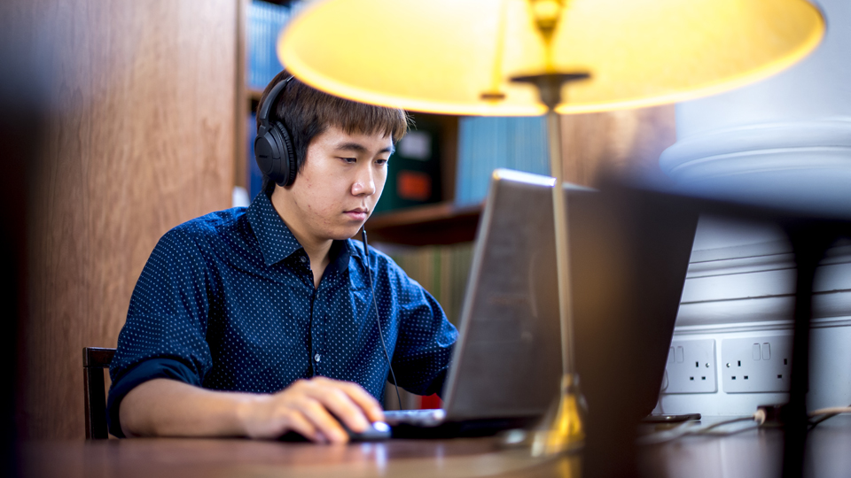 Student working on his laptop in the RCM Library
